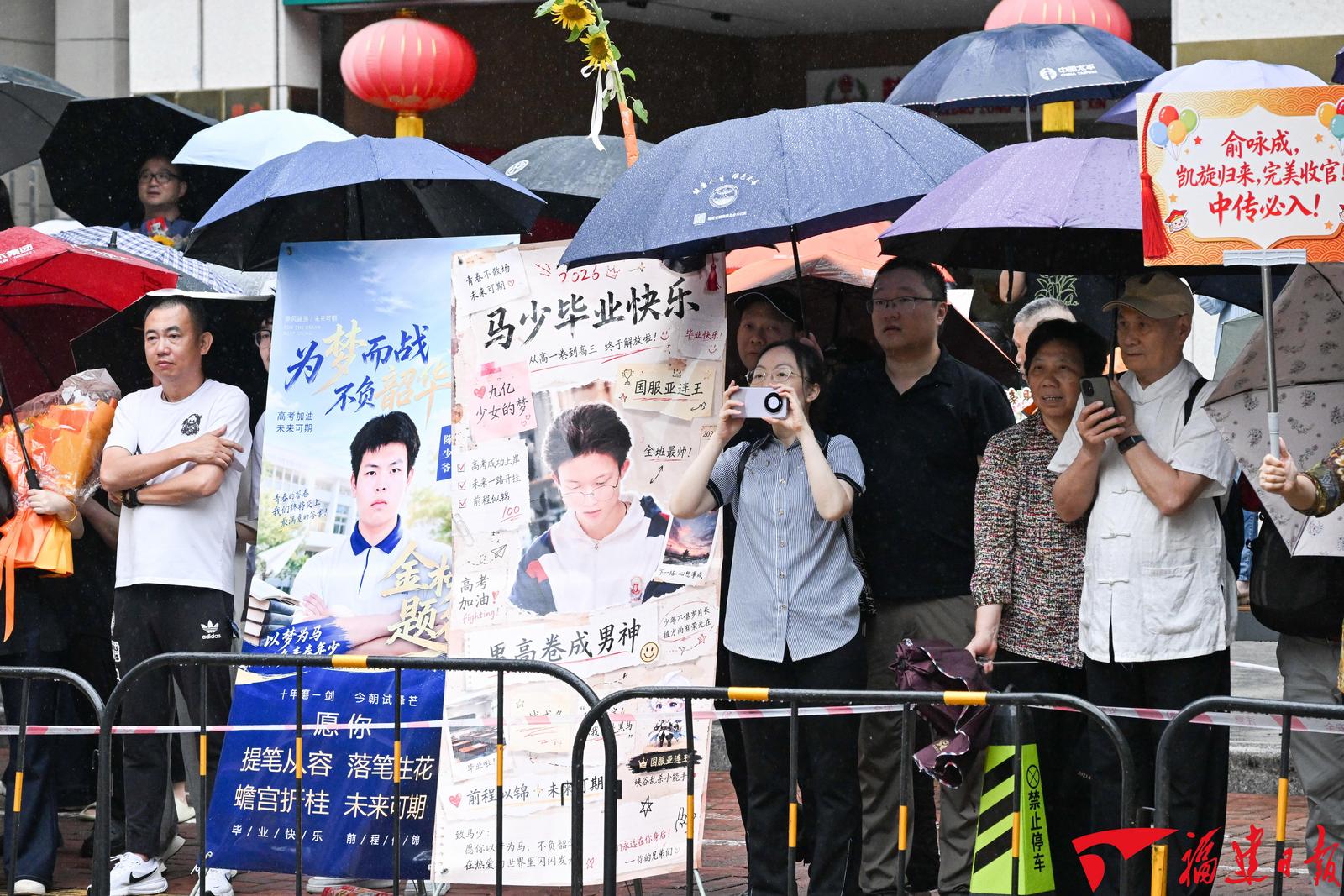 6月9日，福州屏东中学考点外，考生的亲朋好友手捧鲜花、高举横幅、立起易拉宝，满怀期待地等候走出考场的考生。   本报记者 游庆辉 摄