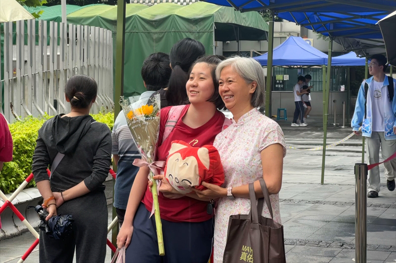 6月9日，福州教育附中考点外，家长手拿花束礼物和考生合影。