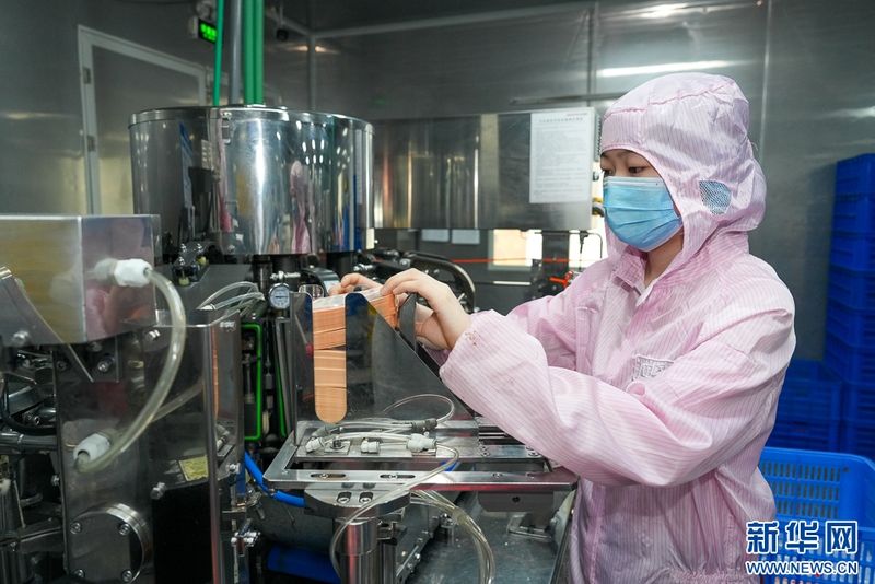 这是福建省渔家翁食品有限公司肉制品生产车间，工人在机台前工作。金融“活水”助力企业引入全自动化设备，大大提高生产效率。新华网 肖和勇 摄