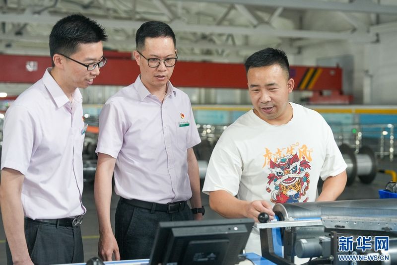 这是信泰（福建）科技有限公司5G智慧工厂织造车间，农行福建晋江支行客户经理向企业职工了解生产经营情况。新华网 肖和勇 摄