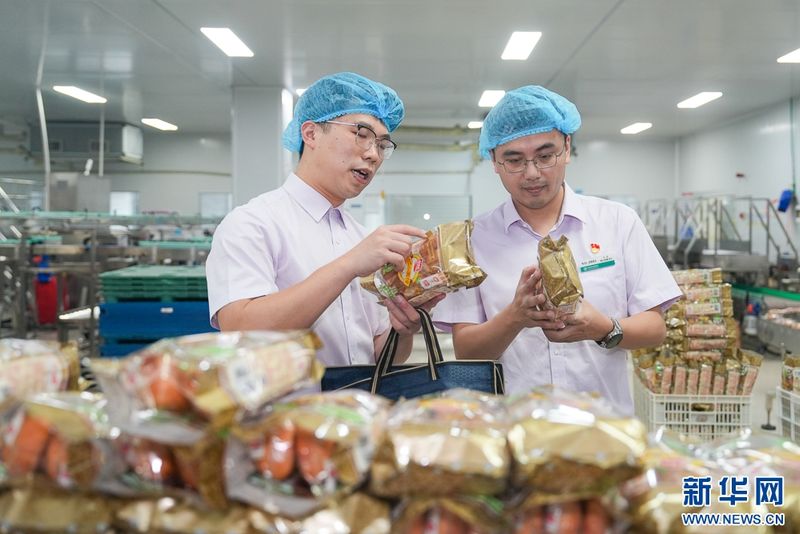 这是盼盼食品集团有限公司5G智慧工厂面包包装车间。农行福建晋江支行客户经理在了解面包生产情况。新华网 肖和勇 摄