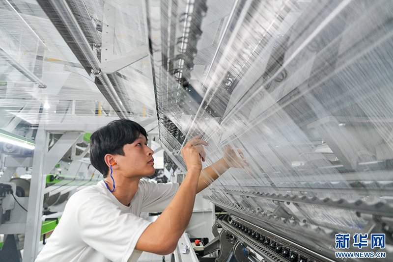 这是信泰（福建）科技有限公司5G智慧工厂织造车间，经编工人在检查纱路状况。金融“活水”助力企业实现技术升级和转型发展。新华网 肖和勇 摄