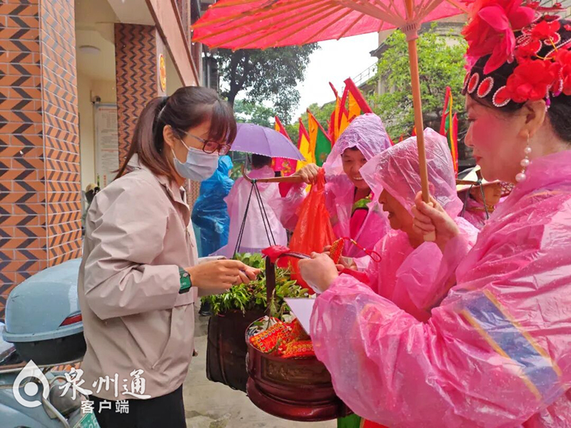 泉州端午传统民俗—“嗦啰嗹”巡游。图为市民领取榕艾枝和香囊。（图片来源：鲤城微事）