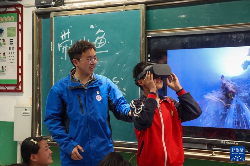 2024年4月23日，支教队员唐晓宇带领学生用VR眼镜在沉浸式课堂看海底世界。新华社发