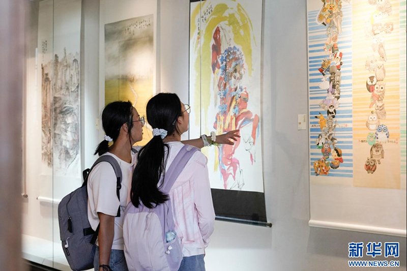 两位学子在馆内观看展出作品。新华网 蒋巧玲 摄