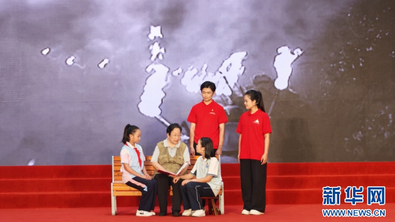 宁化老红军黄承衍之女黄金芳（左二）与学生们重温长征历史，讲述革命先辈的奋斗历程。新华网 刘丰 摄