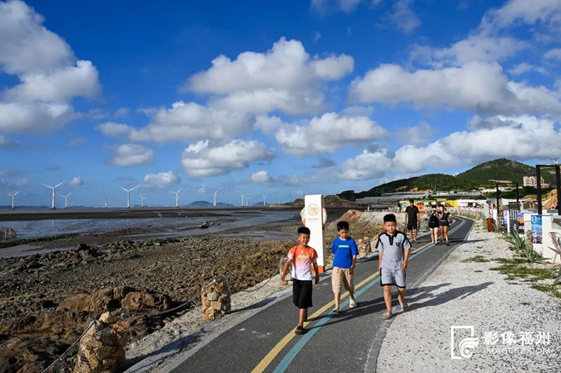 滩涂边海风清凉，傍晚游人们在海边步道散步。记者 池远 摄
