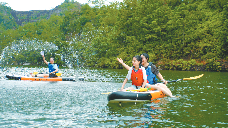 连城县九龙湖景区水上桨板体验区内，游客乘桨板漫游湖面戏水，尽享山水间的清凉惬意。通讯员 项志伟 摄