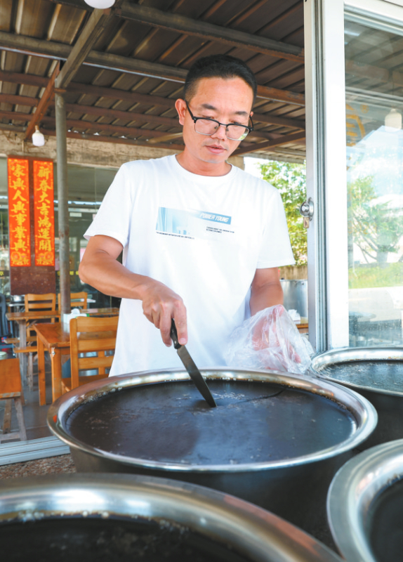 新罗区东肖街道一家小食店内，店主正在切割手工熬制的烧仙草。记者 谢泽铧 摄