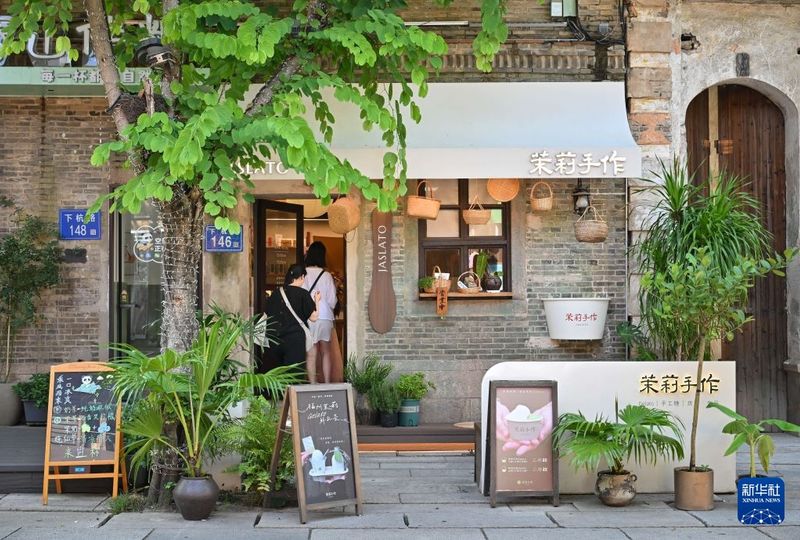 7月22日，游客走进位于福州上下杭历史文化街区的一家茉莉花甜品店。新华社记者 韩旭 摄
