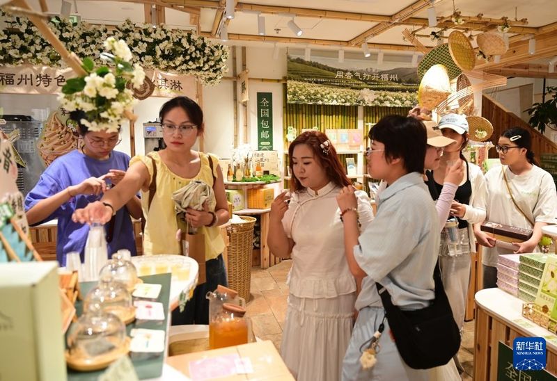 7月22日，游客在福州三坊七巷历史文化街区南后街的一家茉莉花茶店参观品尝茉莉花茶。新华社记者 林善传 摄