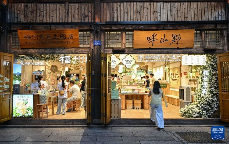 7月22日，游客在福州三坊七巷的一家茉莉花主题店铺内购物。新华社记者 韩旭 摄