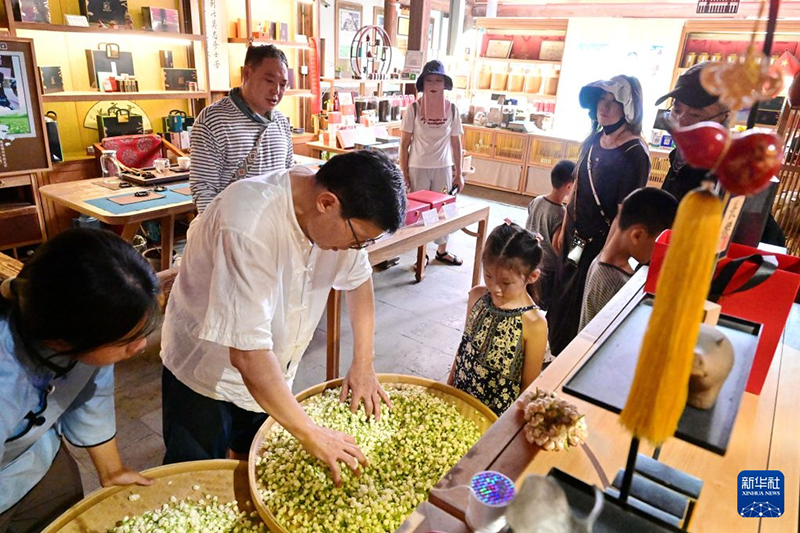 7月22日，游客在位于福州三坊七巷历史文化街区的福州茉莉花茶文化馆了解茉莉花茶制作。新华社记者 林善传 摄