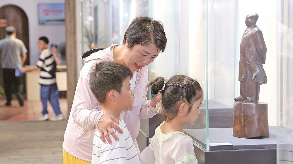 家长引导孩子仔细欣赏根雕作品。