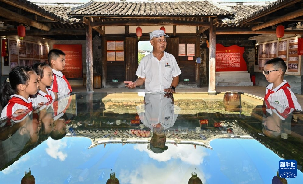 在福建省龙岩市长汀县南山镇中复村,讲解员钟鸣在观寿公祠内为参加红色研学活动的小学生讲解。新华社记者 韩旭 摄
