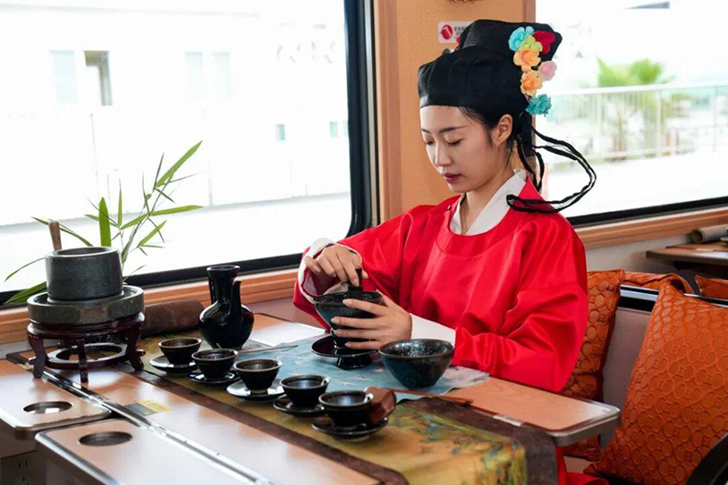试乘旅客在观光列车车厢内体验茶百戏。
