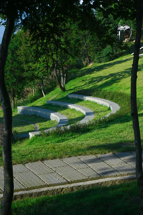 顺着石径继续前行，高大柳杉沿路成排，树影婆娑蔽去燥热，月季、玫瑰等随风轻摆，似在欢迎人们的到来。