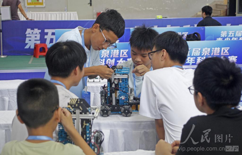 7月30日，在福建省泉州市泉港区益海实验小学荷盈馆机器人（篮球模拟）中学组候赛区，选手在检查、调校参赛机器人。