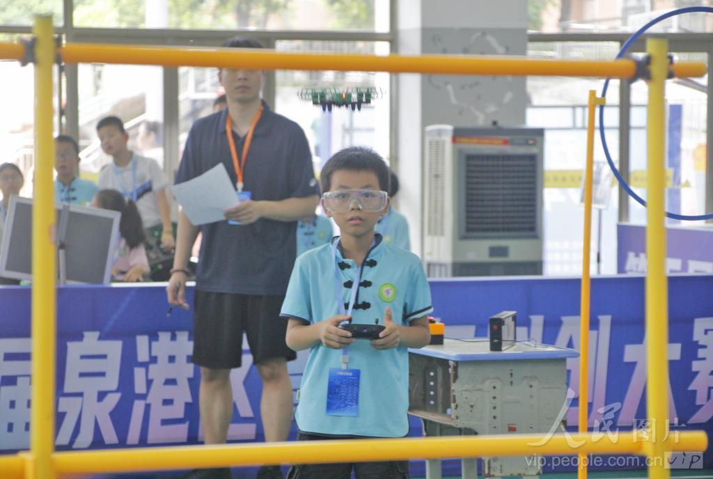 7月30日，在福建省泉州市泉港区益海实验小学荷盈馆无人机个人飞行赛小学组赛场上，选手操控无人机穿梭于障碍赛道。