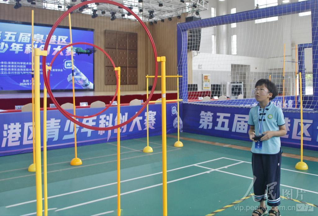 7月30日，在福建省泉州市泉港区益海实验小学荷盈馆无人机个人飞行赛小学组赛场上，选手操控无人机穿梭于障碍赛道。