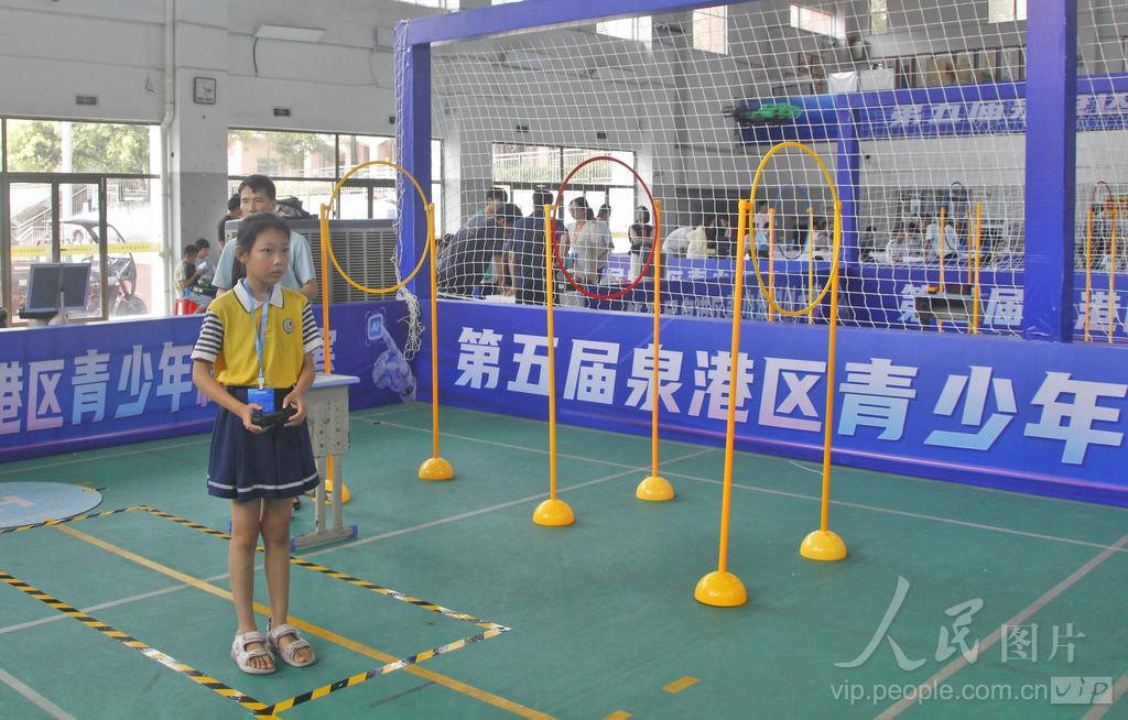 7月30日，在福建省泉州市泉港区益海实验小学荷盈馆无人机个人飞行赛小学组赛场上，选手操控无人机穿梭于障碍赛道。