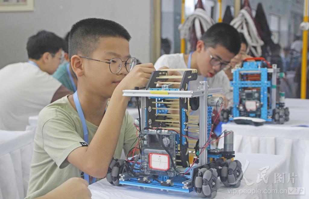 7月30日，在福建省泉州市泉港区益海实验小学荷盈馆机器人（篮球模拟）中学组候赛区，选手在检查、调校参赛机器人。