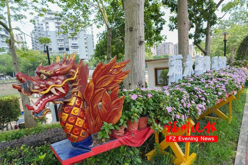 温泉公园码头旁的花圃里，龙舟遨游在花圃的“绿浪”之上，船上的“游客”变成了花开正盛的凤仙花。记者 包华 摄