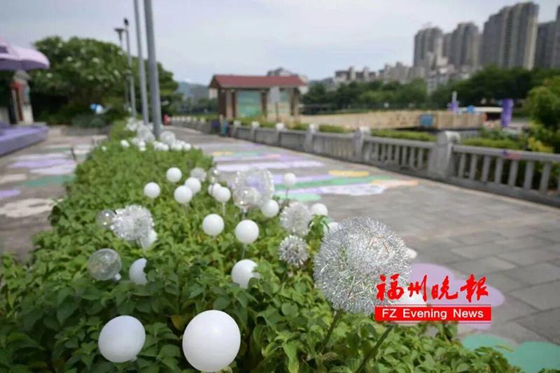 一整片紫色休闲椅，一整片紫色遮阳伞，一整片梦幻花境，往休闲椅上一躺，光明港的河岸风景尽收眼底，浪漫的氛围感直接拉满。记者 包华 摄