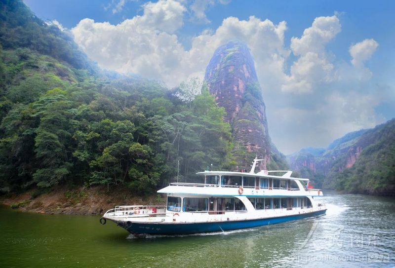 福建泰宁大金湖，观光游船航行湖面，高耸丹霞石柱矗立岸边，游客乘船欣赏水上丹霞风光。