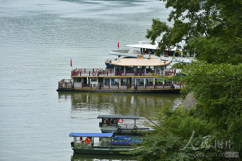 泰宁大金湖白水漈瀑布景点，湖面停泊多艘观光船只，湖岸林木葱郁。