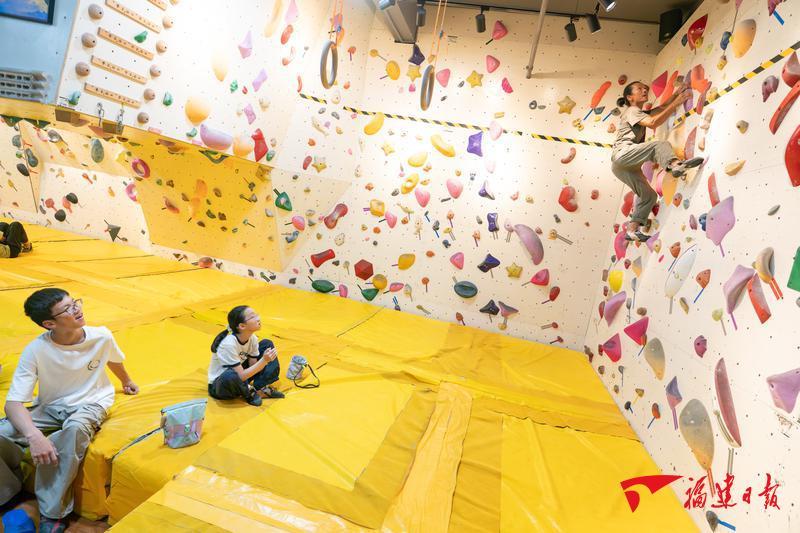 7月5日，在县城的攀岩馆，郑斌的儿女看着爸爸展示新线路的攀爬。
