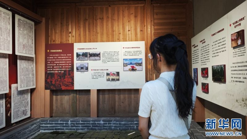 8月5日，在三明市宁化县曹坊镇下曹村革命旧址，一名参与活动的代表认真阅览展板记载的红色革命故事。新华网 刘默涵 摄