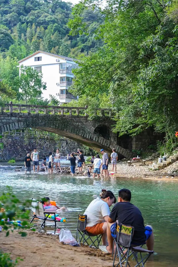 溪水很浅，踩进清凉的溪水里，能看见灵动的小鱼在脚边游动。