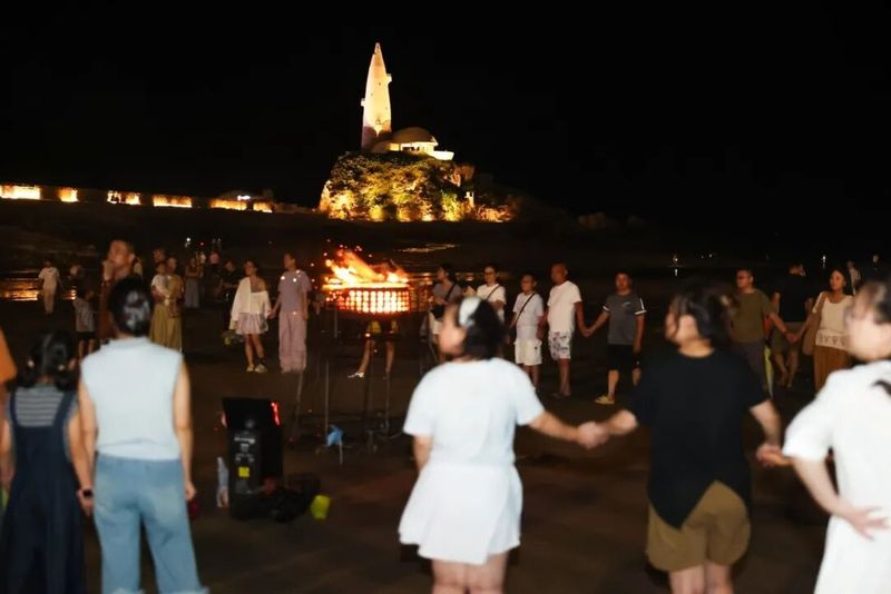 沙滩上,篝火晚会同步点燃,火光映照着食客们的笑脸,与海面上跳动的月光交相辉映。