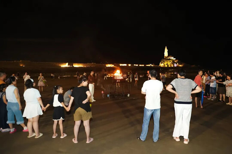 沙滩上,篝火晚会同步点燃,火光映照着食客们的笑脸,与海面上跳动的月光交相辉映。