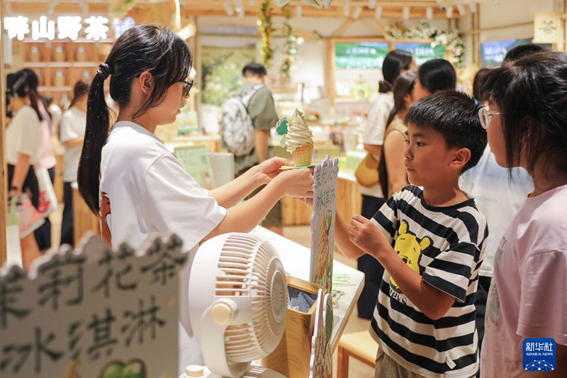 8月17日，小顾客在福州市三坊七巷历史文化街区“畔山野·福州茉莉主题店”内购买茉莉花茶冰淇淋。新华社记者 杜潇逸 摄