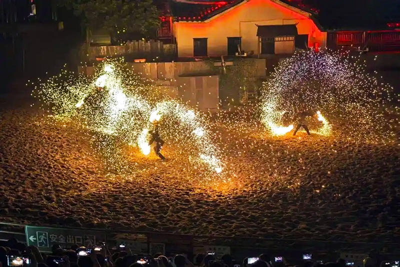 沙滩上的“火树银花”备受关注，铁水泼洒的瞬间，金红色火星如瀑布倾泻，游客惊呼声此起彼伏。