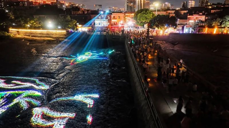 夜幕下，市民游客手提以“投荔传情”为灵感设计的荔枝灯，漫步洛阳桥和桥南古街。