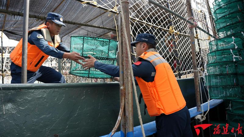 开渔前夕，漳州海警局执法员为出海渔民整理物资。蔡晓晔 摄