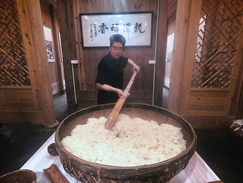 陈官唱在演示红粬黄酒酿造过程中的“糯米饭摊凉”步骤。新华网记者 唐斓 摄