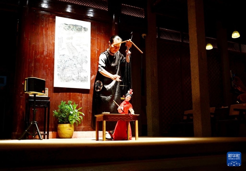 8月18日，泉州市木偶剧团演员在洛江区桥南古街的余庆楼里表演提线木偶写书法。新华社记者 林善传 摄
