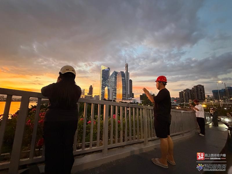 这场浪漫的晚霞盛宴也吸引了市民驻足拍照。