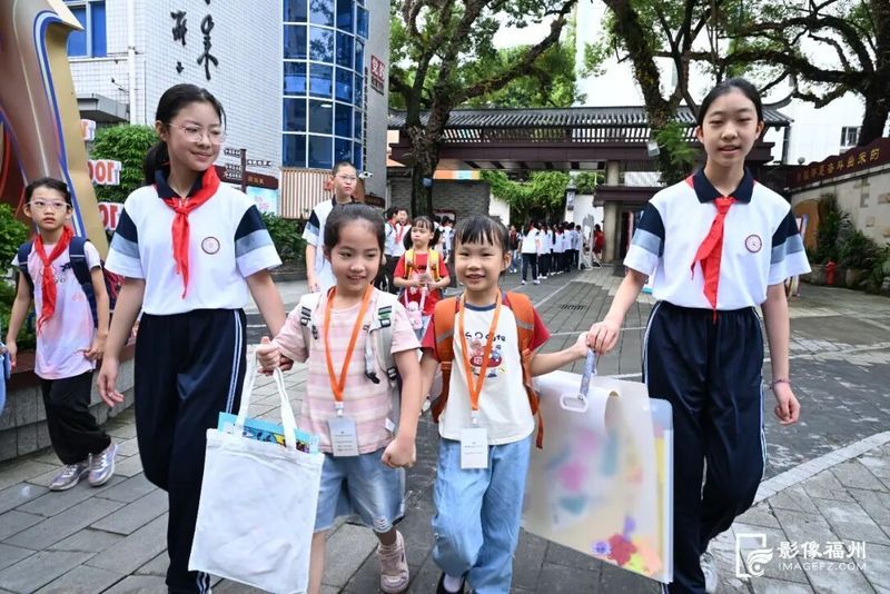 六年级学长学姐牵手一年级新生,陪伴他们步入校园。记者 叶诚 摄