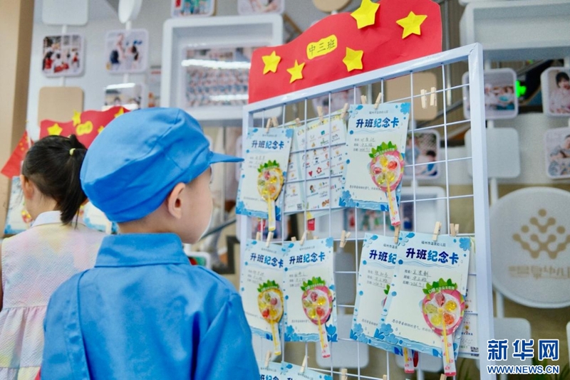 9月1日，福州市温泉幼儿园开展秋季开学系列活动。图为孩子们驻足观看升班纪念卡，开启新学期的成长旅程。新华网发（福州市温泉幼儿园供图）