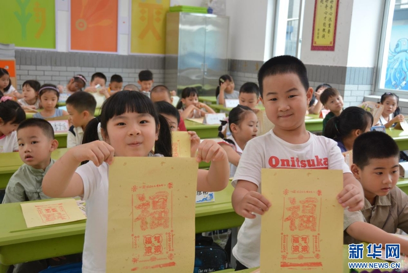 8月30日，福州市鼓楼第一中心小学举行一年级新生入学仪式，将非遗技艺融入开学第一课。图为学生们展示自己制作的拓印作品。新华社记者 张华迎 摄