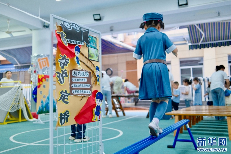 9月1日，福州市温泉幼儿园开展“红色浸润童心 金秋逐梦启航”秋季开学系列活动，为孩子们送上别样的“开学第一课”。图为小朋友走过平衡木，体验“飞夺泸定桥”的惊险。新华网发（福州市温泉幼儿园供图）
