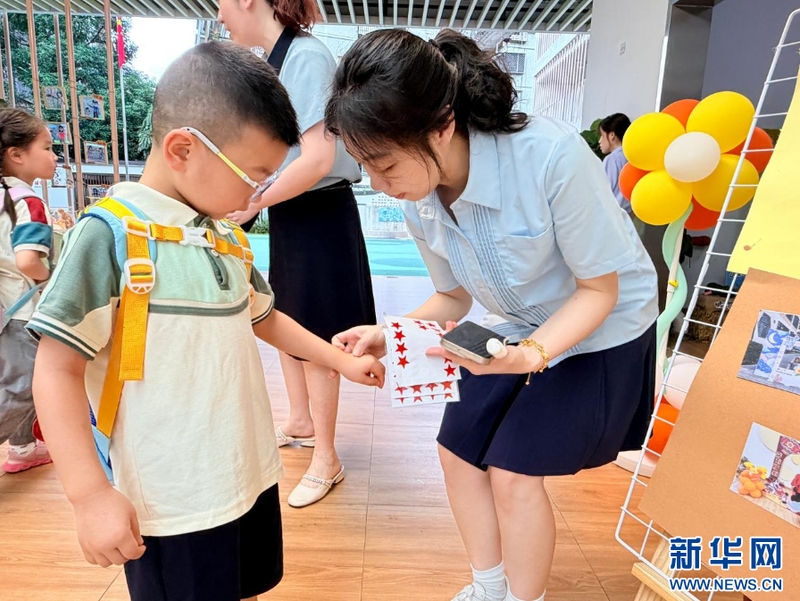 9月1日，福州延安中学集团延安幼儿园开展红色集星闯关活动，开启充满仪式感的新学期。图为老师为闯关成功的孩子贴上闪亮的红星。新华网发（福州延安中学集团延安幼儿园供图）