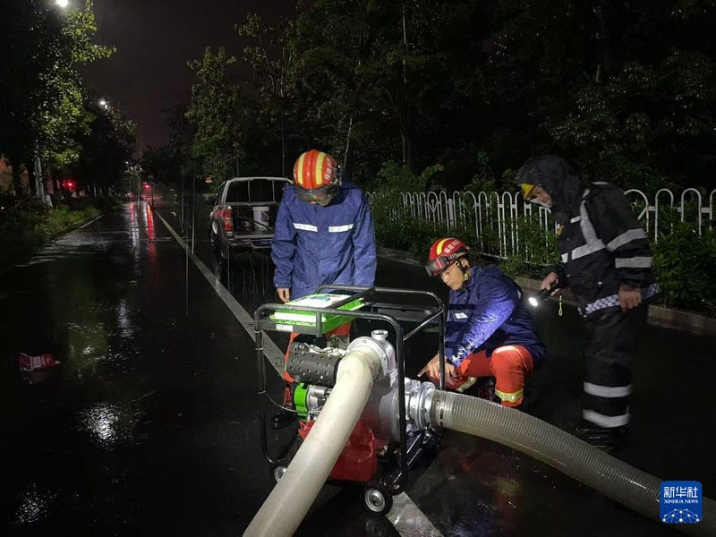 9月3日凌晨，消防救援人员在福建省漳州市古雷开发区街头冒雨操作移动式抽水泵，抽排路面积水。新华社发（詹照宇 摄）