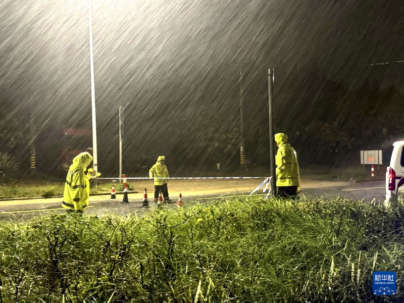 9月3日凌晨，福建省漳州市古雷开发区交警大队民警在雨中设置警戒锥桶、拉设警戒带，引导车辆绕行避险。新华社发（詹照宇 摄）