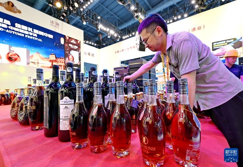 9月7日，工作人员在法国路邑集团展位整理葡萄酒。新华社记者 林善传 摄
